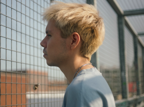 Jesse staring through a chain-link fence