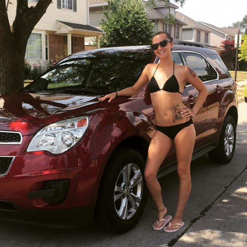 Angel in a bikini next to a minivan