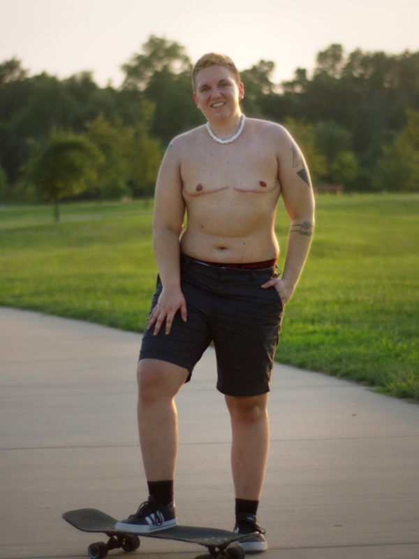 Kase posing shirtless with their skateboard